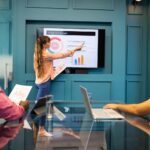 presenting-department-budget-woman-pointing-screen-meeting-with-colleagues