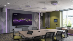 Modern meeting room with ceiling microphones, speakers, acoustic panels, and display technology for professional AV audio solutions.