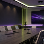 Modern conference room with integrated microphones and display screen for professional Shure audio and AV conferencing solutions.